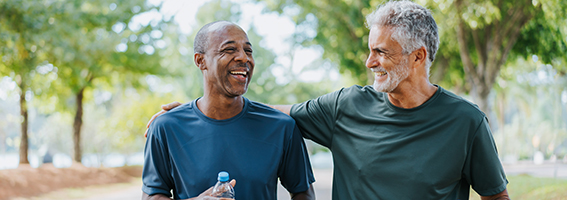 Two men friends walking and laughing outdoors