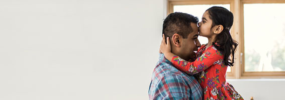Daughter kissing father on forehead