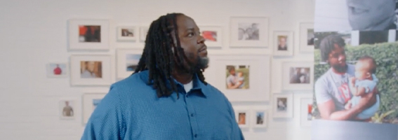 Denardo sits in front of a wall of photos.